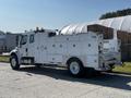 A 2004 Freightliner M2 truck with a white body featuring multiple compartments used for utility or service purposes