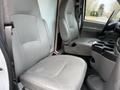 Interior of a 2007 Ford E-350 showing two gray front seats and a console with cup holders