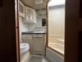 Interior of a bathroom in a 2000 Ford Motorhome featuring a toilet sink mirror and shower stall