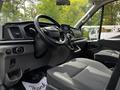 Interior of a 2022 Ford Transit featuring a steering wheel dashboard console and two front seats with a modern design