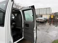 A 2021 Chevrolet Express van with the driver's side door open revealing the interior seating and dashboard