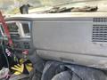 Dashboard of a 2009 Dodge Ram 5500 with various controls and items including gloves and tools in the foreground