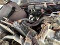 Close-up of the engine compartment of a 2014 Toro Groundmaster 5910 showing various hoses and components intertwined with dirt and debris