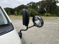 A side view of a 2009 Toyota Hiace showing the black side mirror and the round rearview mirror reflecting the vehicle's side
