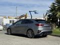 A gray 2024 Kia Forte5 parked with a sleek design featuring sporty accents and alloy wheels