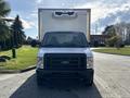 A white 2023 Ford E-450 box truck with a front grille and headlights visible standing straight on