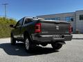 A 2022 RAM 3500 truck in a dark color with chrome accents parked in a lot showcasing its rear view and tailgate design