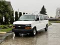 A white 2021 Chevrolet Express van with black trim parked on a wet surface