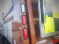 A brown 2016 International WorkStar 7500 truck with red and white tail lights and a bed featuring a reflective safety sign on the side