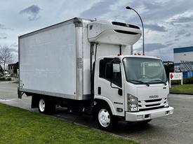 A 2018 Isuzu NRR truck with a refrigerated body painted white parked on a street with a grass verge