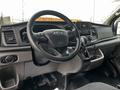 Interior view of a 2020 Ford Transit with a steering wheel and dashboard displaying controls and a touchscreen display