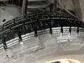 Close-up of a tire from a 2012 Ford Econoline showing tread patterns and a wet surface