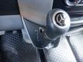 Close-up of the gear shifter in a 2016 Mercedes-Benz Sprinter featuring a black leather grip and silver emblem