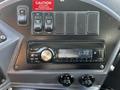 Dashboard controls of a 2022 Blue Bird Vision featuring a radio display indicating FM station 633 with buttons for front auxiliary and transmission settings