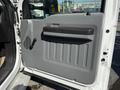 Interior door panel of a 2011 Ford F-550 featuring a black handle and textured gray surface with vertical ridges