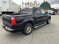 2004 Ford Explorer Sport Trac in black with a crew cab design and a cargo bed visible at the rear side showing chrome accents and running boards