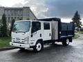 A white 2015 Isuzu NPR HD truck with a flatbed and a metal storage compartment on the side