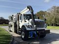 A white 2013 International 7400 truck equipped with a large black suction hose and multiple attached tanks for industrial cleaning purposes