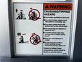 Warning sign for a 2000 JLG 12SP lift detailing safety precautions against crushing and tipping hazards