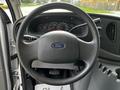 The interior of a 2004 Ford Econoline with a steering wheel and dashboard displaying speedometer and other gauges