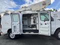 A white 2008 Ford Econoline van with its side doors open revealing a work area filled with tools and equipment