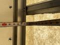 A tape measure showing measurements from 80 to 95 inches positioned next to a metal frame