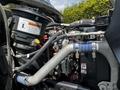Close-up of the engine components of a 2010 Freightliner M2 106 including hoses wires and an air filter with a warning label