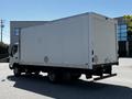A white 2020 Hino 155 box truck parked with its rear facing the camera showcasing a large, empty cargo area
