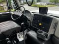 Interior of a 2017 International WorkStar 7600 featuring a steering wheel gauges gear shift and control panel with various buttons and a digital display