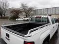 A white 2015 GMC Sierra 1500 pickup truck with an aluminum ladder rack installed in the truck bed