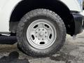 A close-up of a silver wheel with rugged all-terrain tire on a 2011 Ford F-250 SD showcasing the detail of the rim and tread pattern