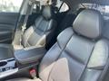 Interior of a 2017 Acura TLX featuring black leather seats with a center console and armrest between the front seats