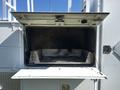 The open compartment of a 2004 Freightliner M2 showing a spacious interior without any items inside