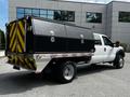 A 2016 Ford F-550 truck with a black tool box mounted in the bed featuring reflective yellow and red markings on the back