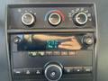 Dashboard controls of a 2014 Chevrolet Express featuring knobs for temperature and fan speed along with a digital display showing radio frequency 532 FM 2 and other audio settings