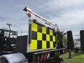A 2016 Freightliner 108SD truck featuring a rear signaling board with alternating yellow and black squares and lights on the top and sides