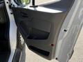 The image shows the open driver's side door of a 2023 Ford Transit highlighting the interior door panel with a grip handle and storage compartment