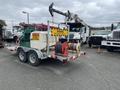 A 2011 Hightliner Aquacide Hot Water Weed Control Dual Flat Deck Trailer with a green tank a hose reel and warning signage attached