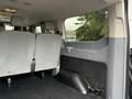 Interior view of a 2018 Ford Transit showing empty gray seats and a flat cargo area with a plastic storage compartment