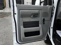 Interior door panel of a 2021 Ford E-450 featuring a handle, control mechanism, storage space, and the embossed "E-Series" logo