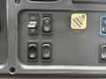 Close-up of a control panel featuring various switches labeled for marker lights, mirror heat, and utility lamp on a Freightliner M2 truck