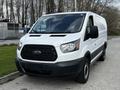 A white 2018 Ford Transit van is shown from the front with a black grille and a streamlined design featuring large headlights and a simple, functional appearance