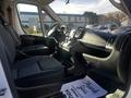 Interior of a 2021 RAM Promaster showing two front seats dashboard and steering wheel with a floor mat that says Thank You Serving you is our pleasure