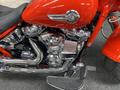 A close-up view of a 2024 Harley Davidson Fat Boy showcasing its chrome engine parts and distinctive red paint detailing