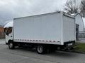 A white 2013 Hino 195 box truck with a closed cargo area and red reflective stripes on the sides