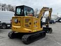 A yellow Caterpillar 306 mini excavator with a bucket attachment and tracks visible, designed for construction and excavation tasks