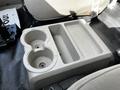 A gray plastic cup holder and storage tray in the interior of a 2008 Ford F-550