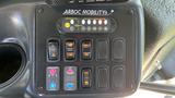 Control panel for a 2011 Chevrolet Express featuring various buttons for door operation and mobility functions