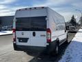 A white 2017 RAM Promaster van parked on the street with a high roof and rear doors closed