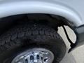 Close-up view of the tire and fender of a 2022 GMC Savana showcasing the tread pattern and chrome wheel rim